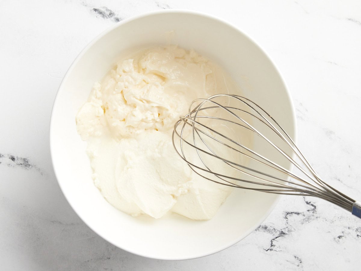 Mayonnaise and ricotta cheese in a mixing bowl.