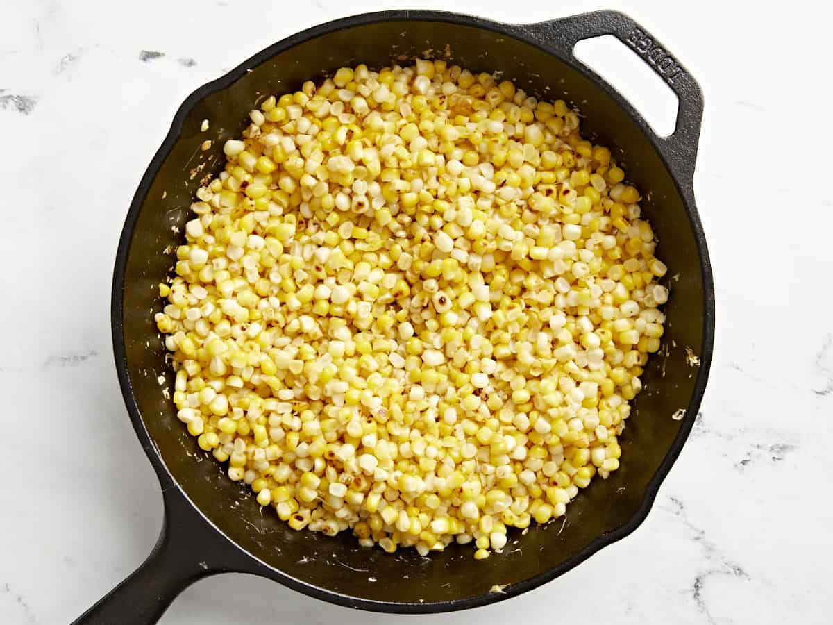 Charred corn kernels in a skillet.