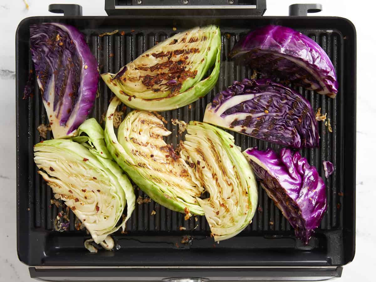 Grilled cabbage wedges on a grill.