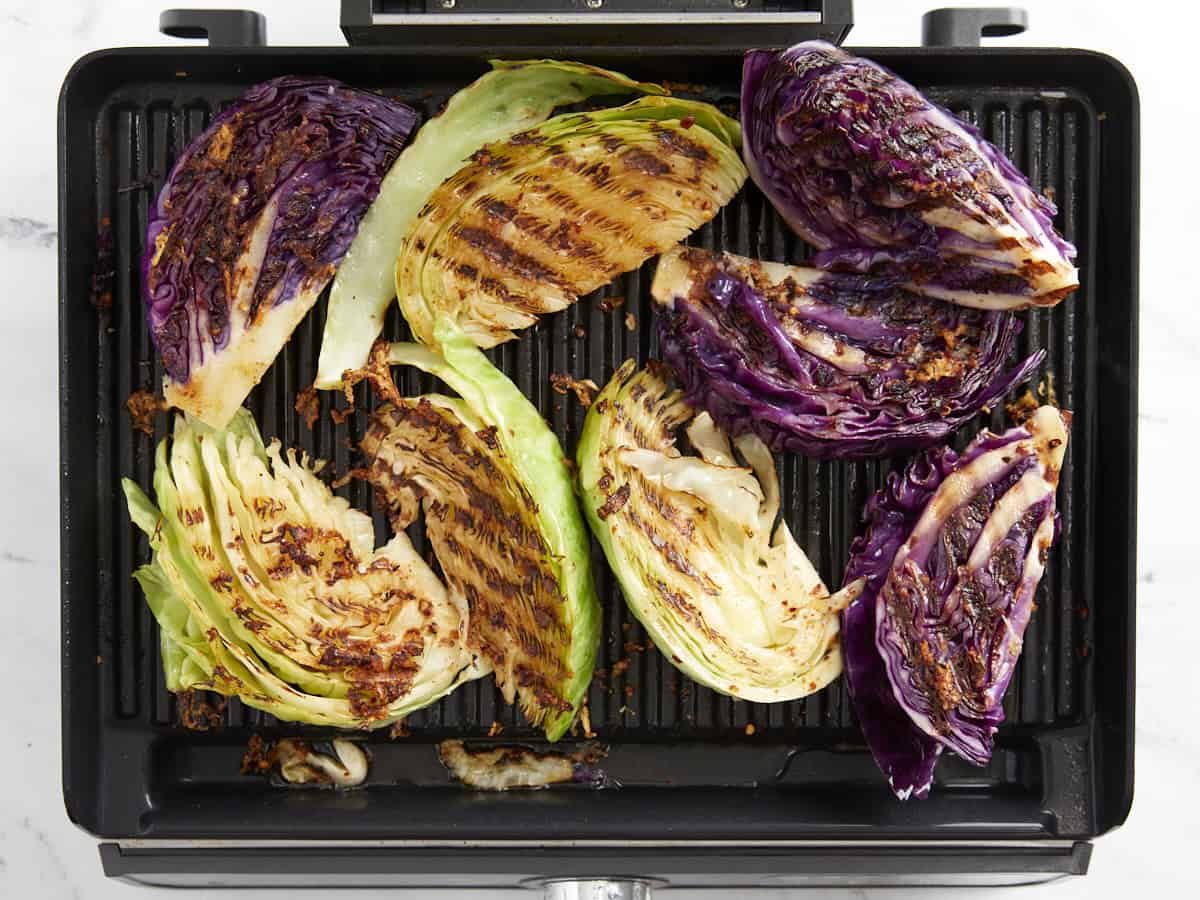 Grilled cabbage wedges on a grill ready to serve.
