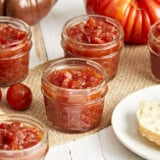 A side view of tomato relish in glass jars.