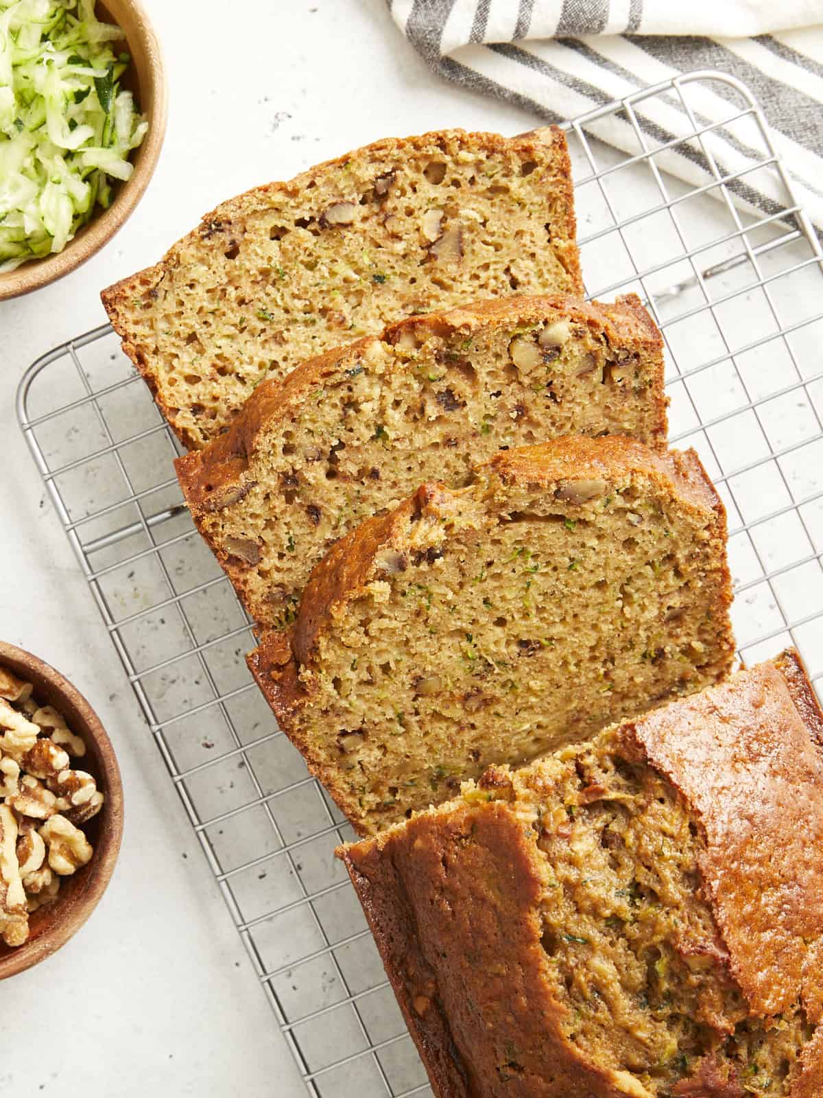 Overhead view of zucchini bread sliced on a cooling rack.