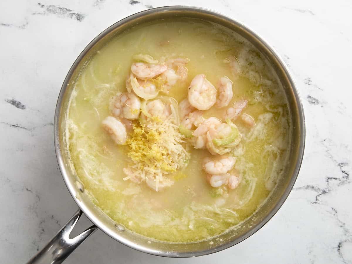 shrimp and white bean stew in a skillet with lemon zest added