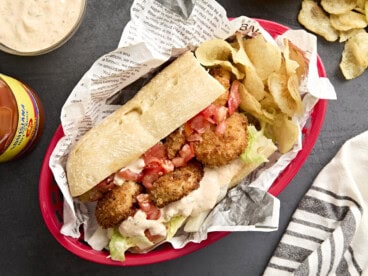 Overhead view of a shrimp po' boy in a basket with potato chips