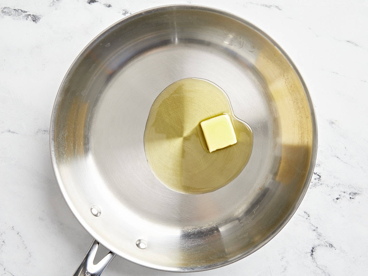 A cube of butter and olive oil in a pan.