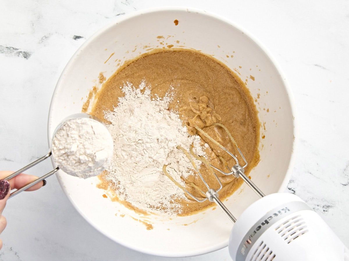 Dry ingredients added to dry ingredients added to a mixing bowl for pumpkin cookies.