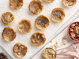 Overhead view of butter tarts on a parchment lined cooling wrack.