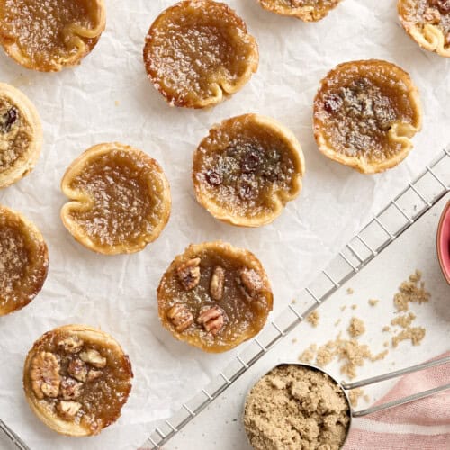 Overhead view of butter tarts on a parchment lined cooling wrack.