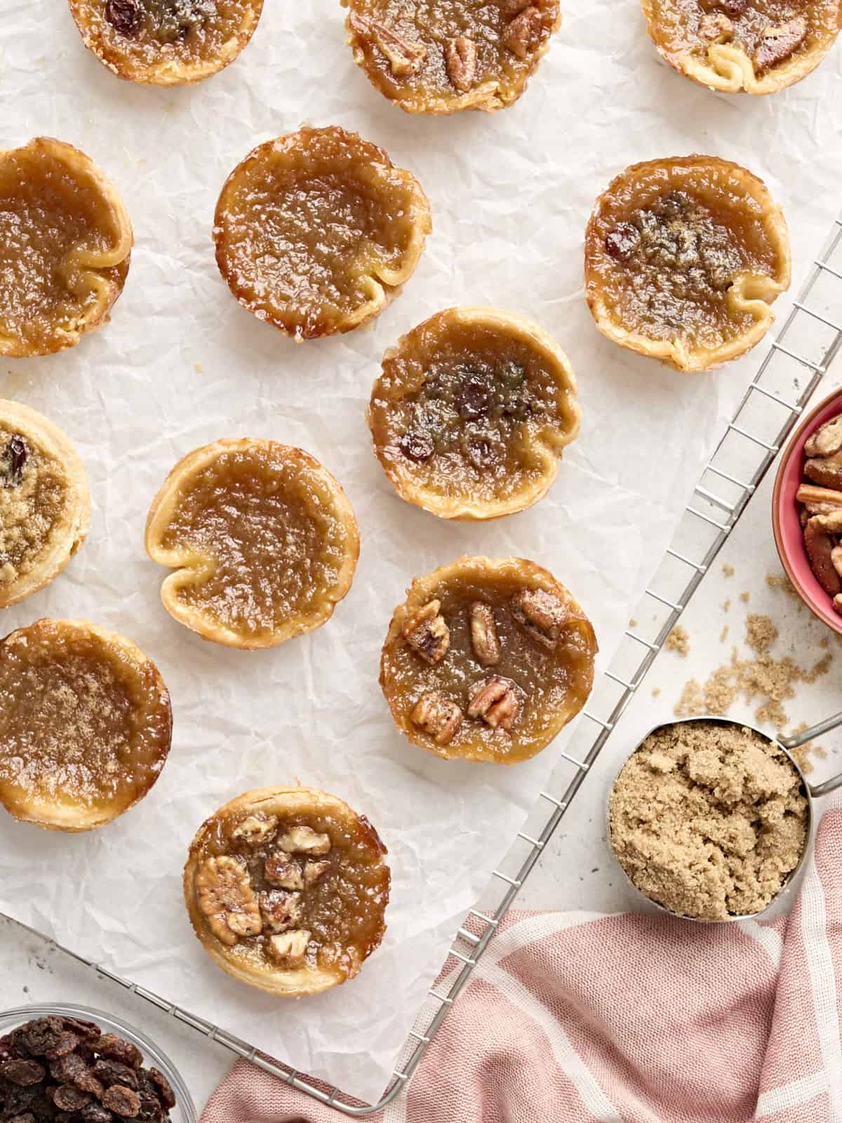 Overhead view of butter tarts on a parchment lined cooling wrack.