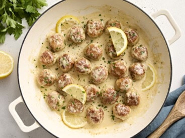 Overhead view of Chicken meatballs in a large skillet with a lemon cream sauce.