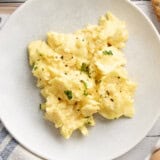 Overhead view of a plate of scrambled eggs.