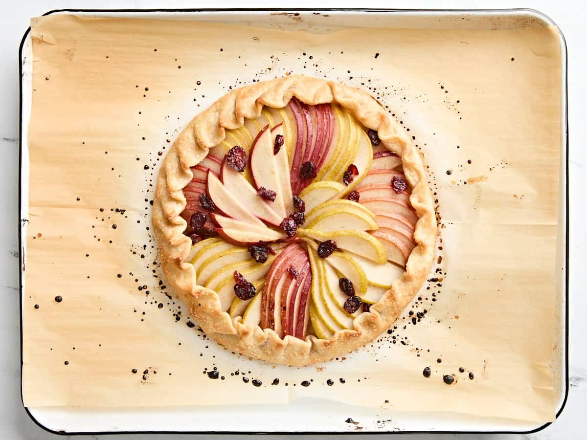 Freshly baked pear galette on a parchment lined baking sheet.