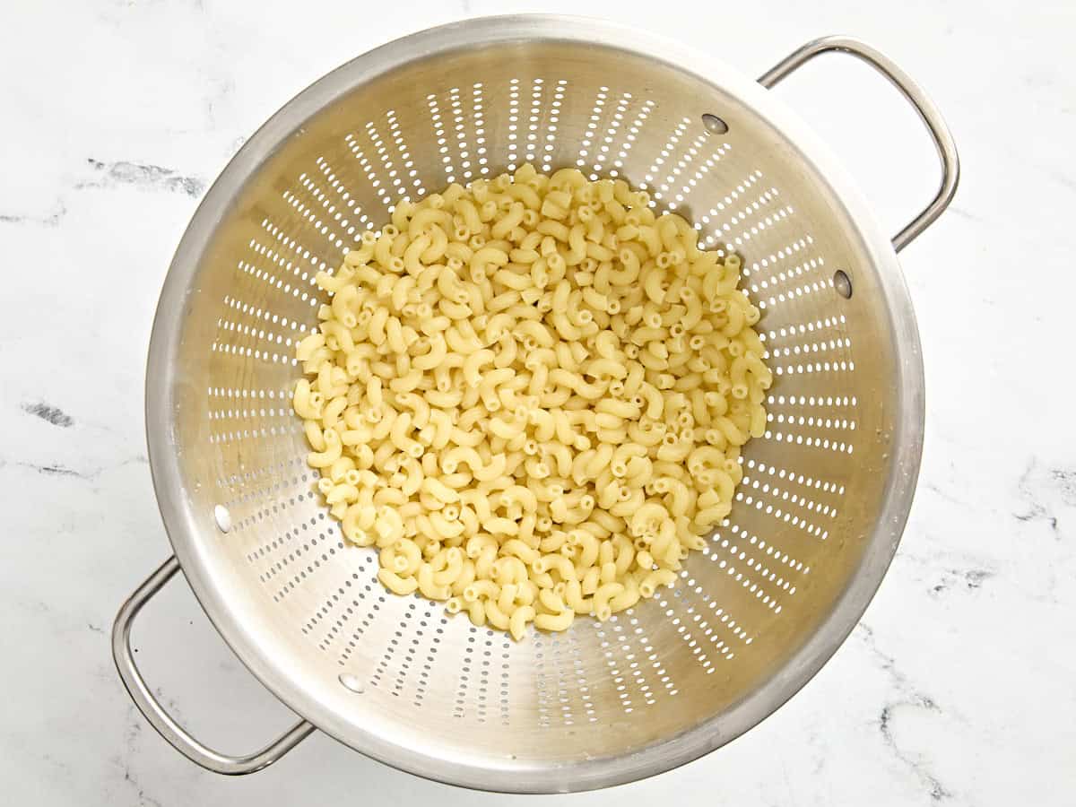 Cooked elbow pasta noodles in a colander.