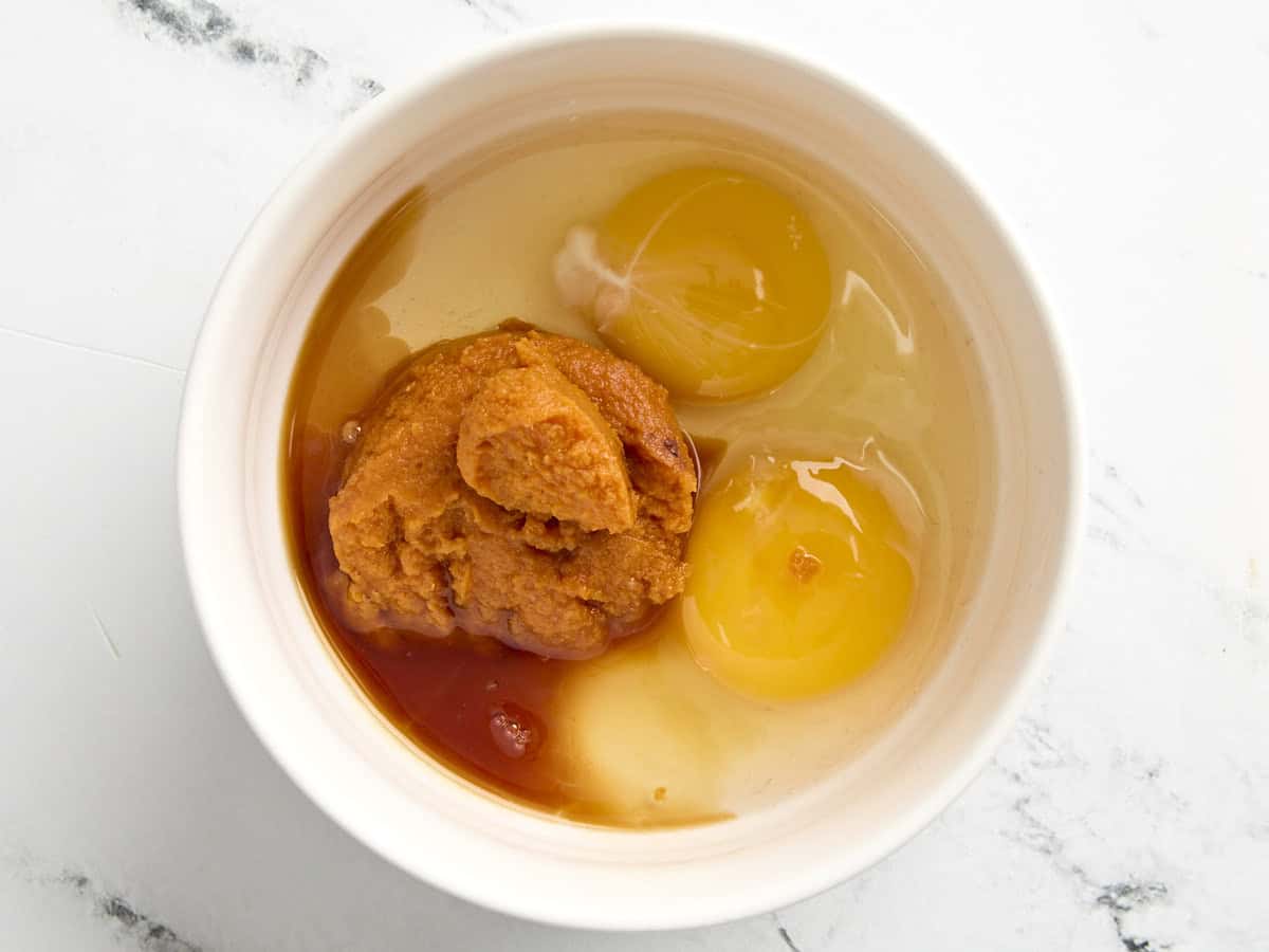 Pumpkin puree, eggs, and vanilla in a mixing bowl.