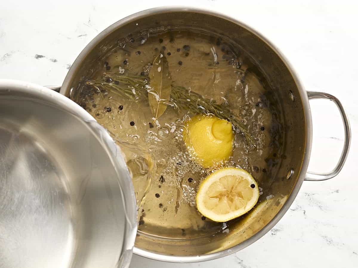 Cold water being added to large pot of water.