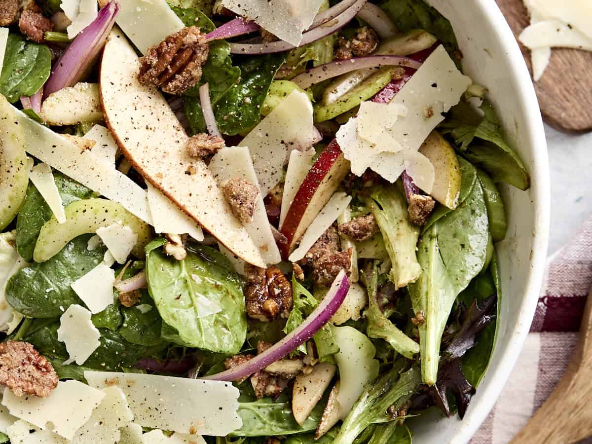 Overhead close up of pear celery and pecan salad in a bowl with parmesan.