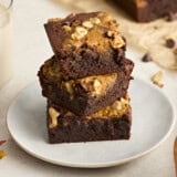 A stack of pumpkin brownies on a plate.