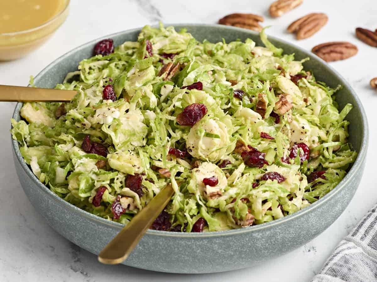 Side view of a bowl of shaved brussels sprouts salad in a bowl.