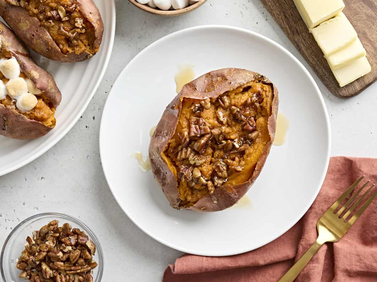 Overhead view of one twice baked sweet potato on a white serving plate with a gold fork on the side.