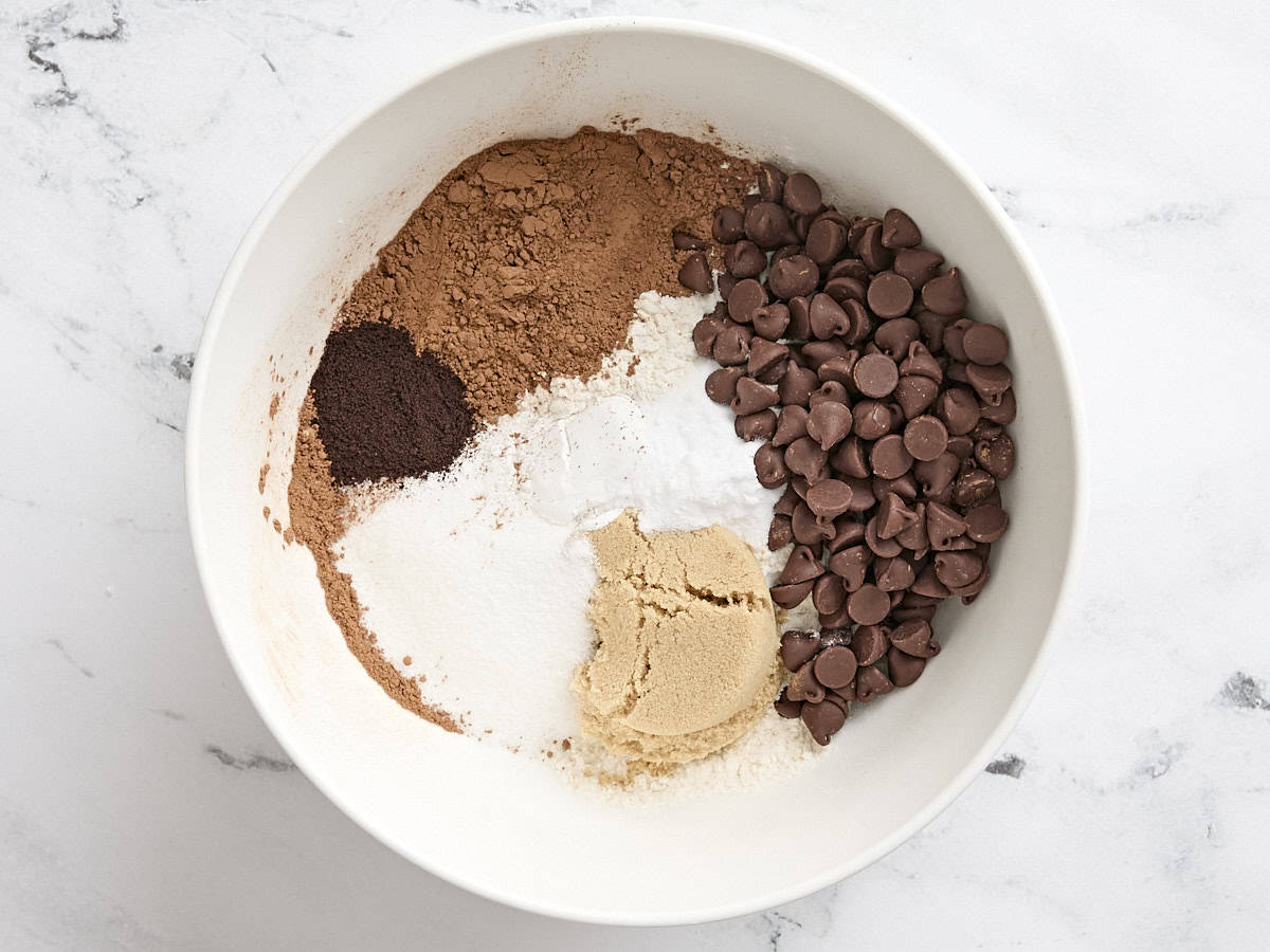 Instant coffee, brown sugar, granulated sugar, flour and chocolate chips in a mixing bowl.