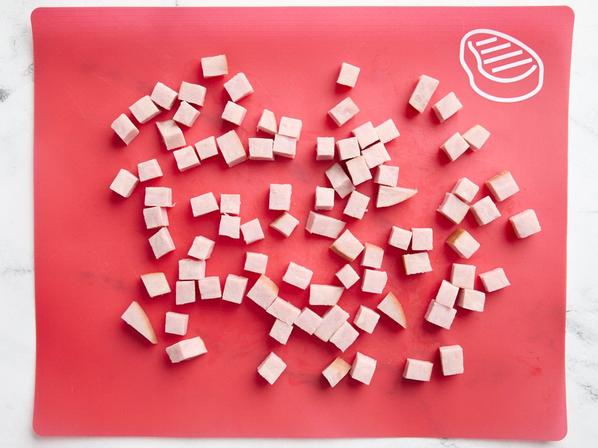 Diced ham steak on a chopping board.