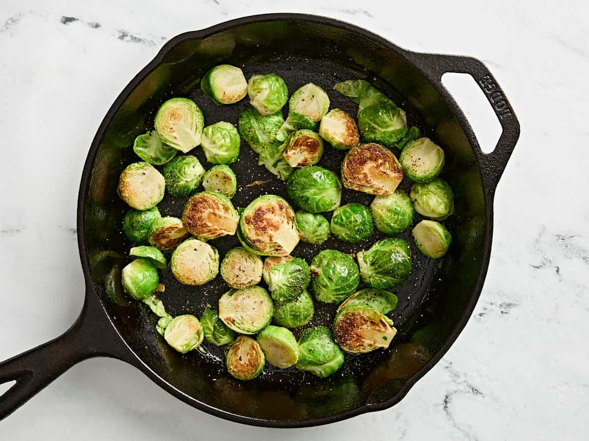 Sauteed brussels sprouts in a cast iron skillet.