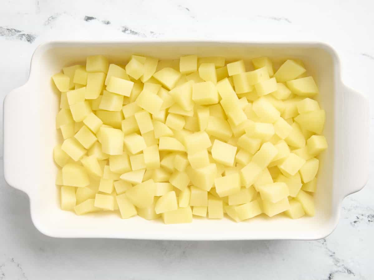 Diced potatoes added to a casserole dish.