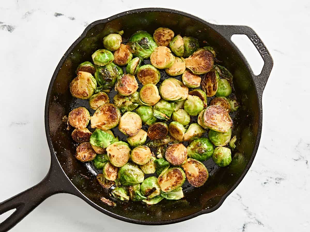 Finished brussels sprouts in a cast iron skillet.