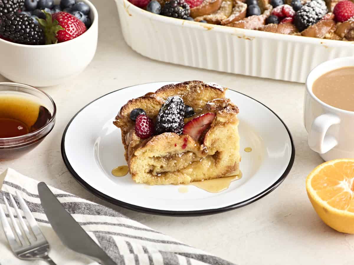 Side view of a slice of baked french toast on a white plate.