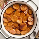 Overhead view of candied yams in a white serving dish.