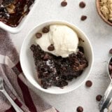 Overhead view of a slice of chocolate pudding cake in a bowl with vanilla ice cream.