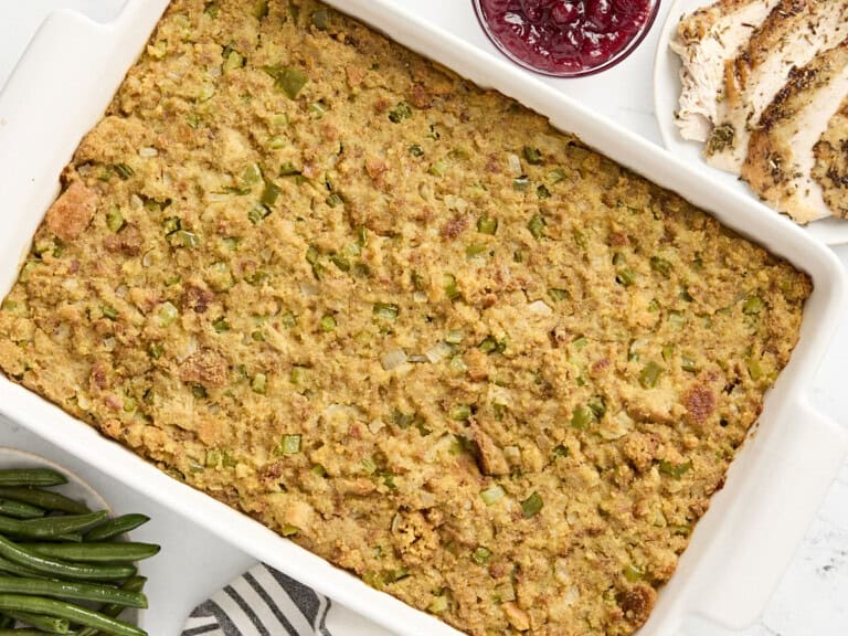 Overhead view of cornbread dressing in a large white baking dish.