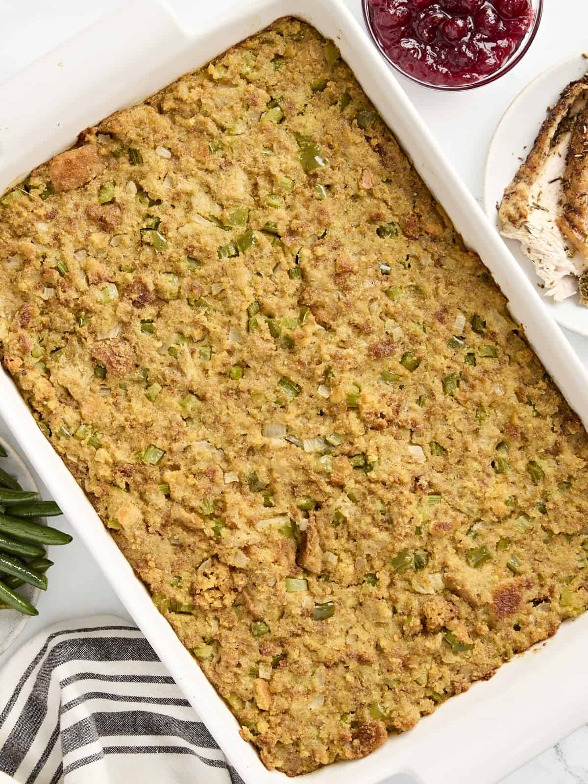 Overhead view of cornbread dressing in a large white baking dish.