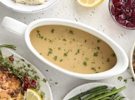 Overhead view of turkey gravy in a gravy boat sprinkled with fresh parsley.