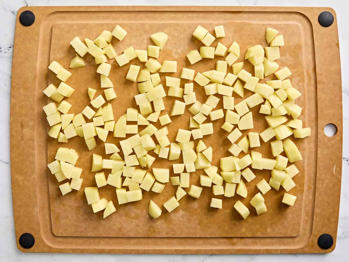 Diced potatoes on a wooden chopping board.