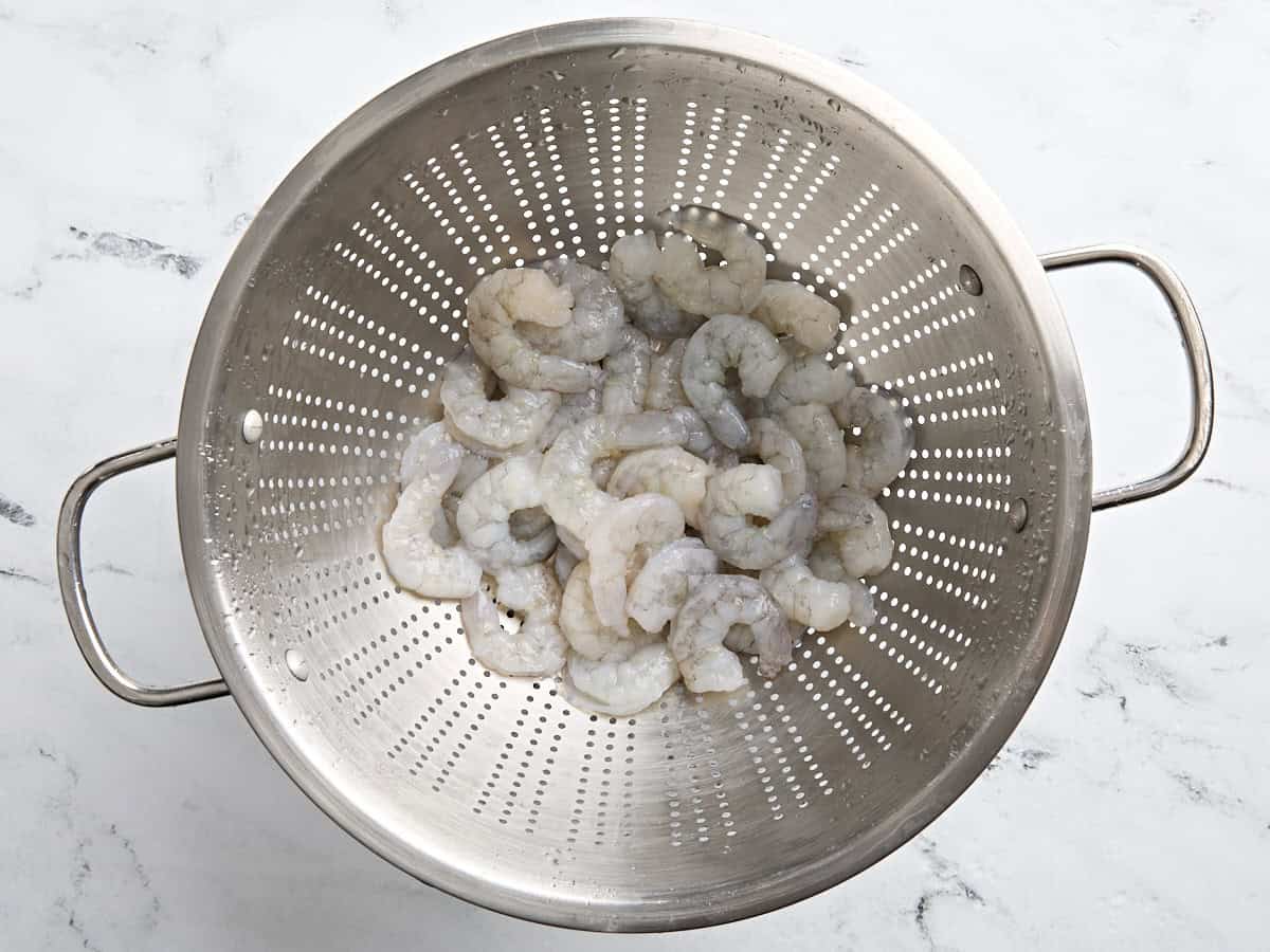 Shrimp thawing in a colander.