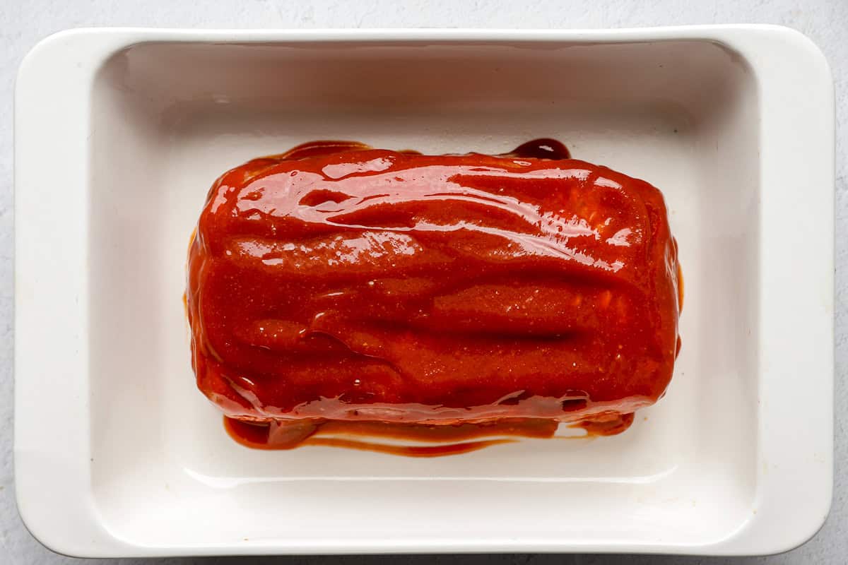 Meatloaf with glaze in a baking dish.