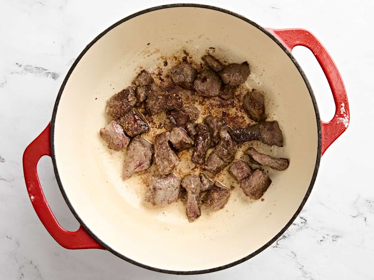 Beef stew meat being browned in a dutch oven.