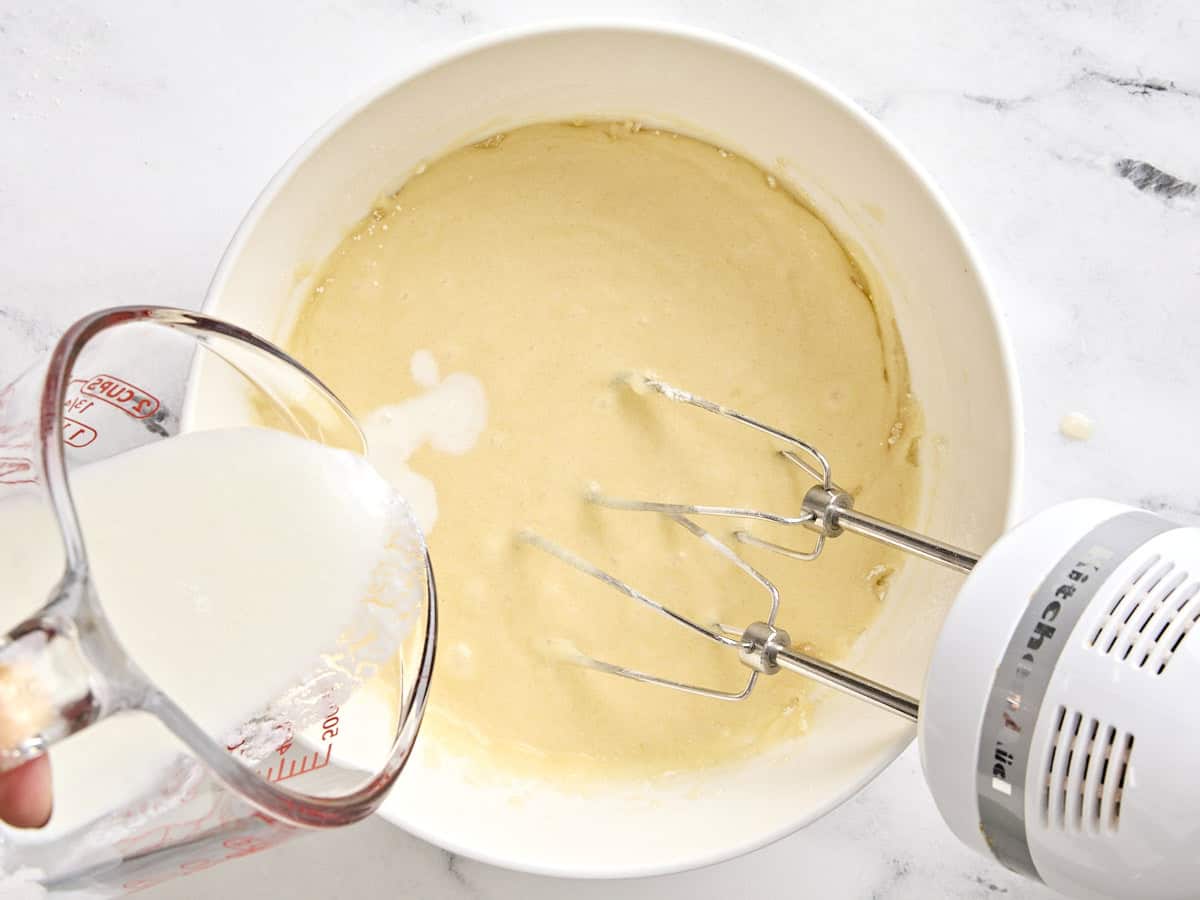 Buttermilk added to the batter for black and white cookies in a bowl.