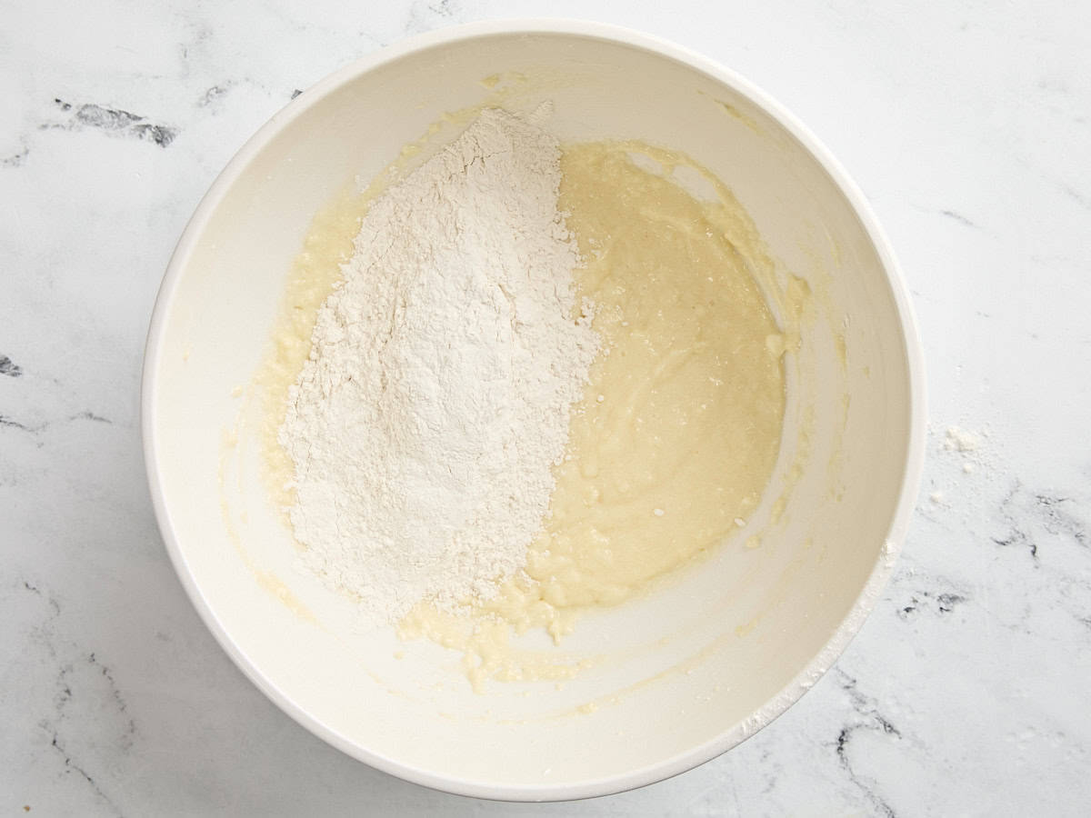 Dry ingredients added to the wet ingredients for coffee cake in a mixing bowl.