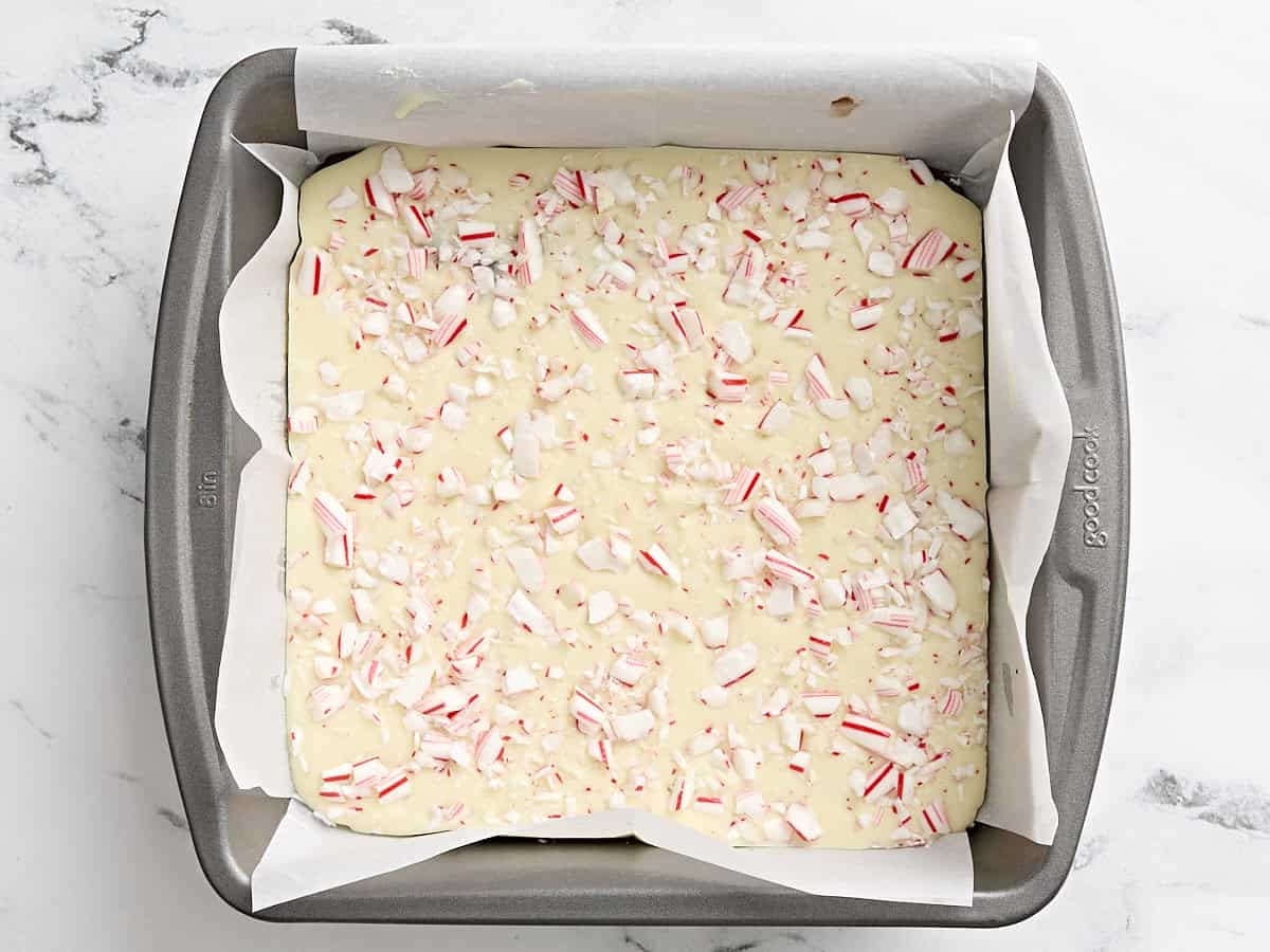 Peppermint bark in a parchment lined baking dish.