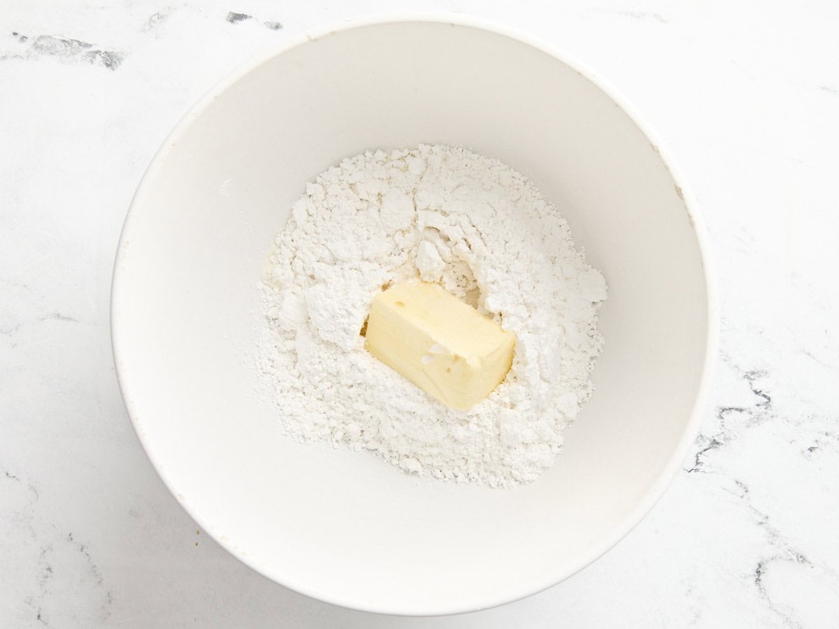 Butter and powdered sugar in a bowl to make frosting for eggnog cookies.