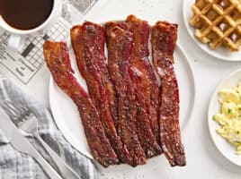 Overhead view of candied bacon on a plate.