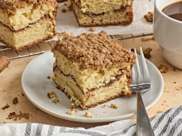 Side view of a slice of coffee cake on a plate with a fork.