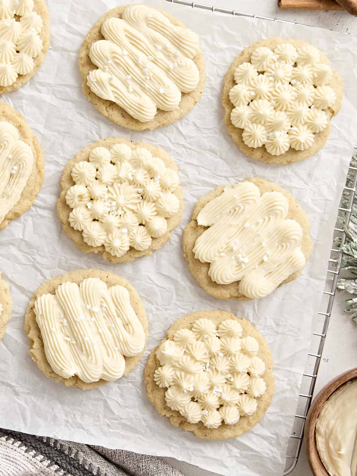 Overhead view of frosted eggnog cookies on a parchment lined cooling rack.