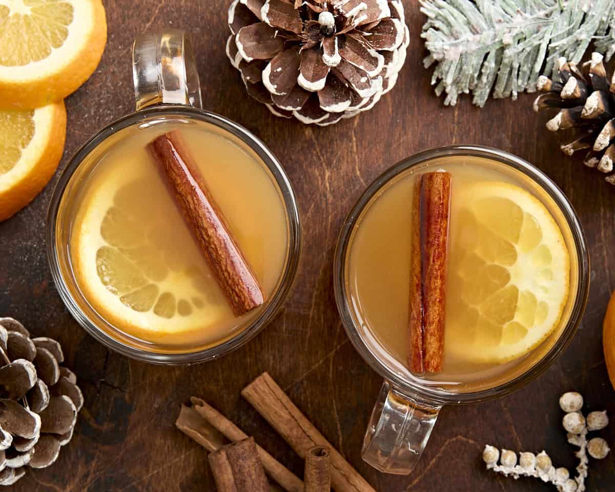 Overhead view of two mugs of hot apple cider.