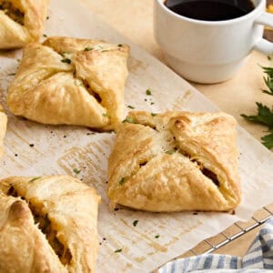 Side view of sausage and cheese hand pies on parchment paper.