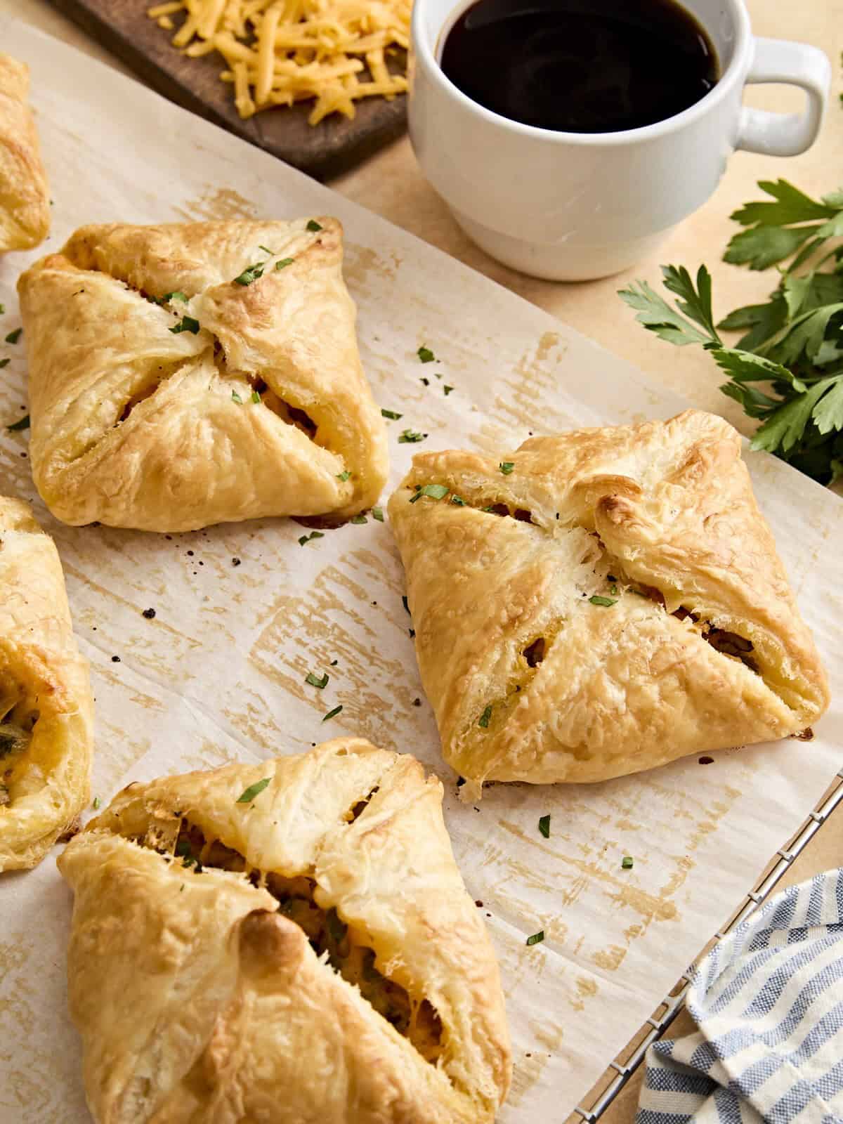 Side view of sausage and cheese hand pies on parchment paper.