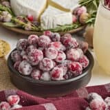 Side view of a bowl of sugared cranberries.