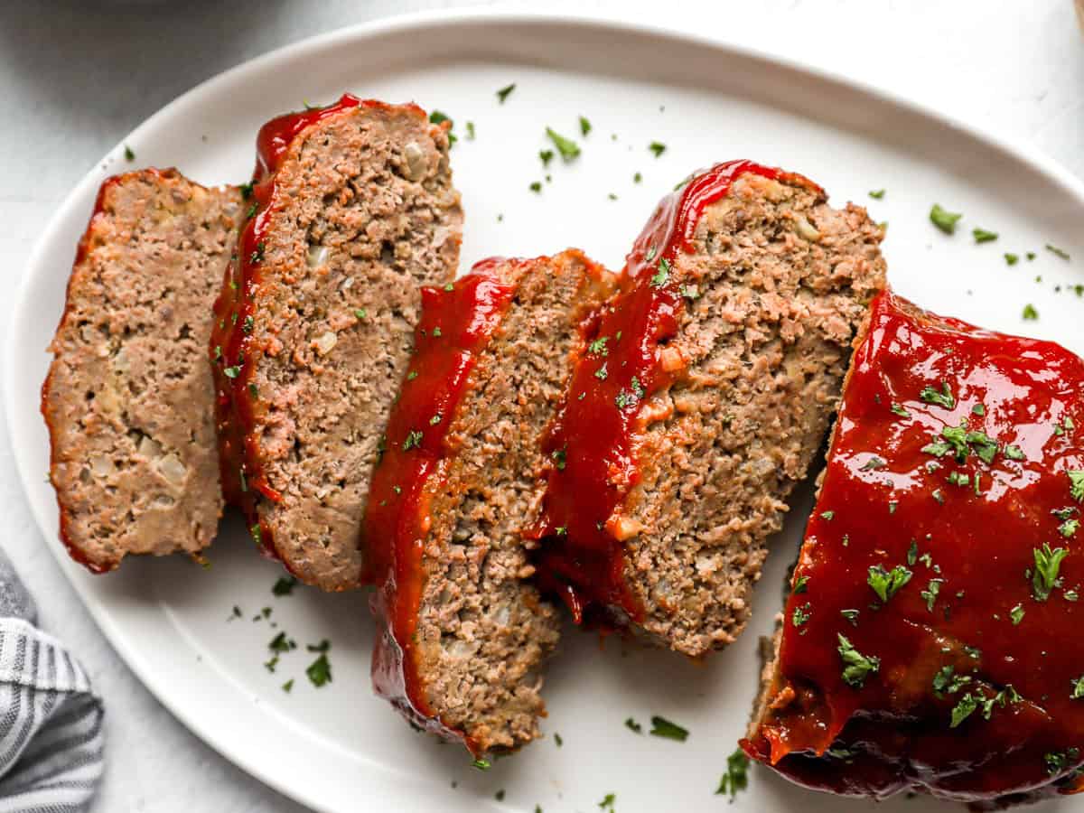 Overhead close up view of homemade meatloaf slices on a platter.